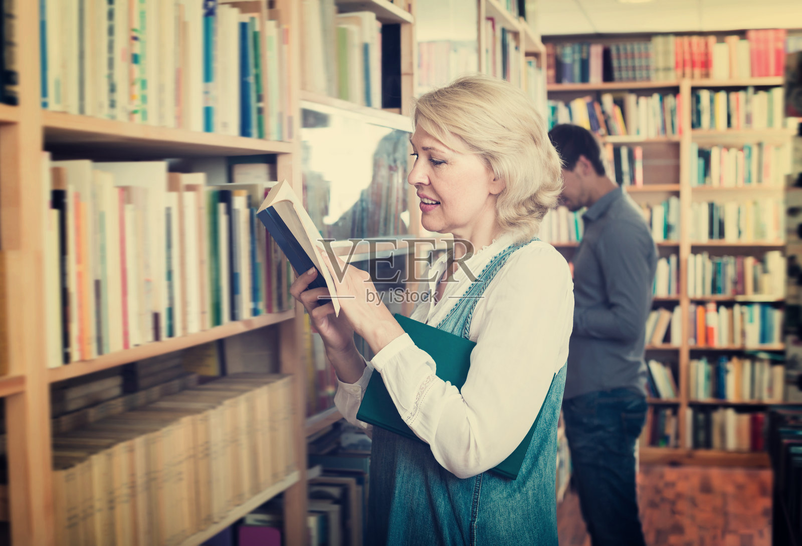 快乐的女人在书店看书照片摄影图片