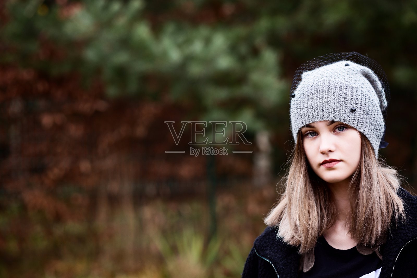 戴灰色羊毛帽子的体贴的年轻女子照片摄影图片