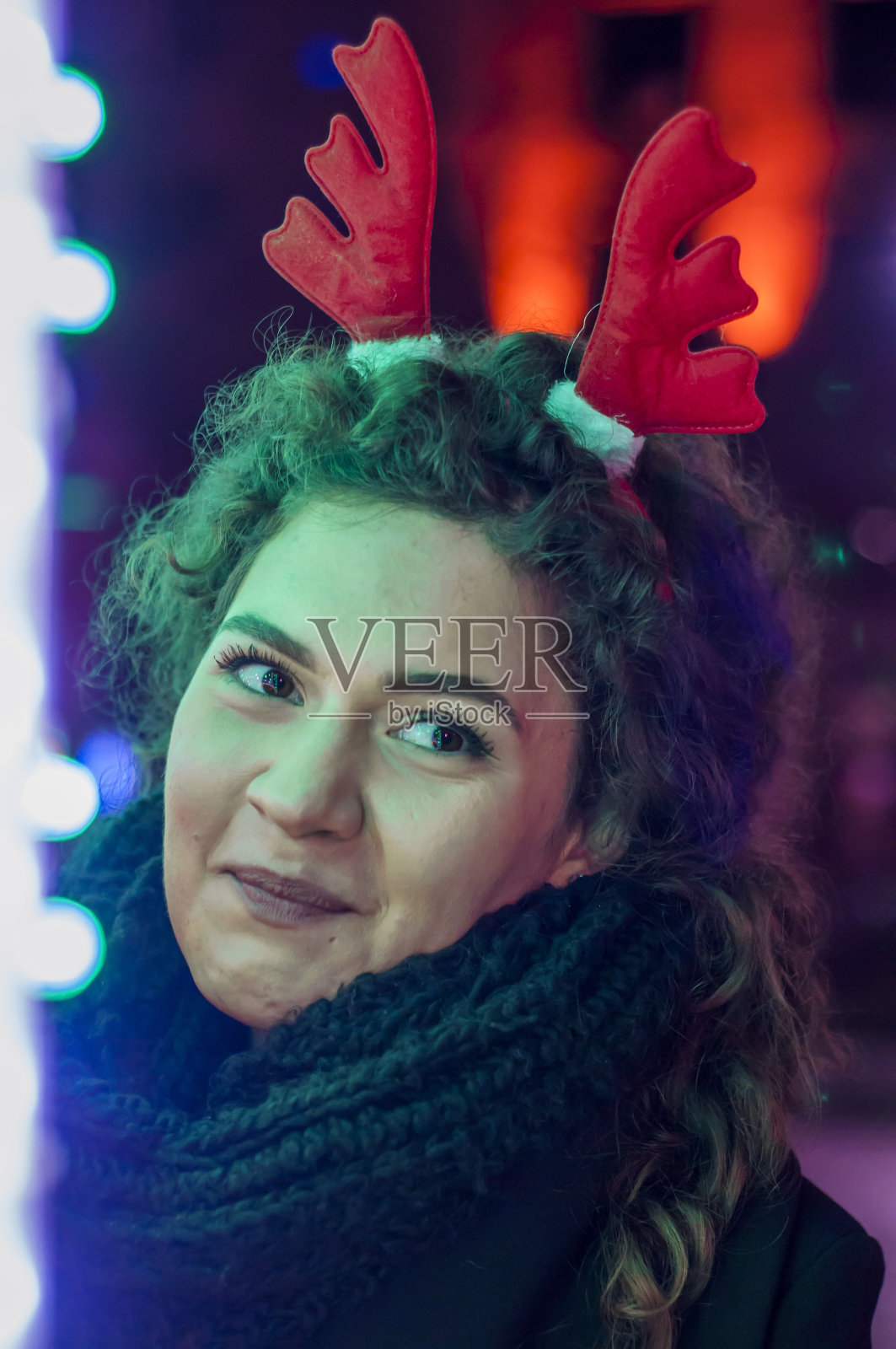 年轻快乐的女人晚上带着圣诞装饰散步照片摄影图片