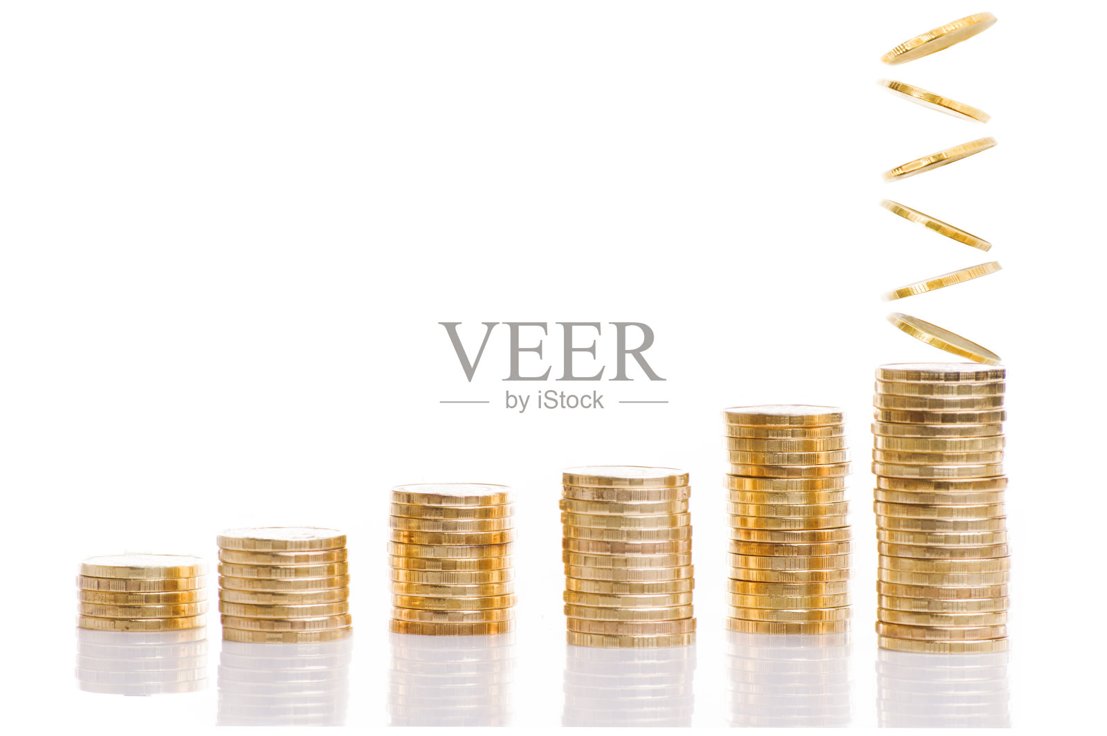 经营理念。一堆金币落在白色的地上。照片摄影图片