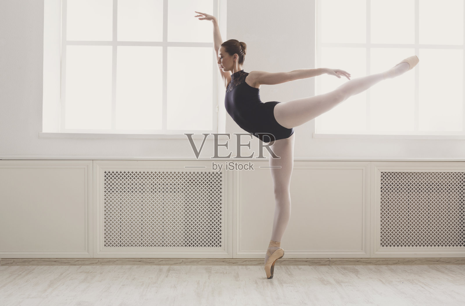 美丽的芭蕾舞者站在阿拉伯式芭蕾舞姿势照片摄影图片