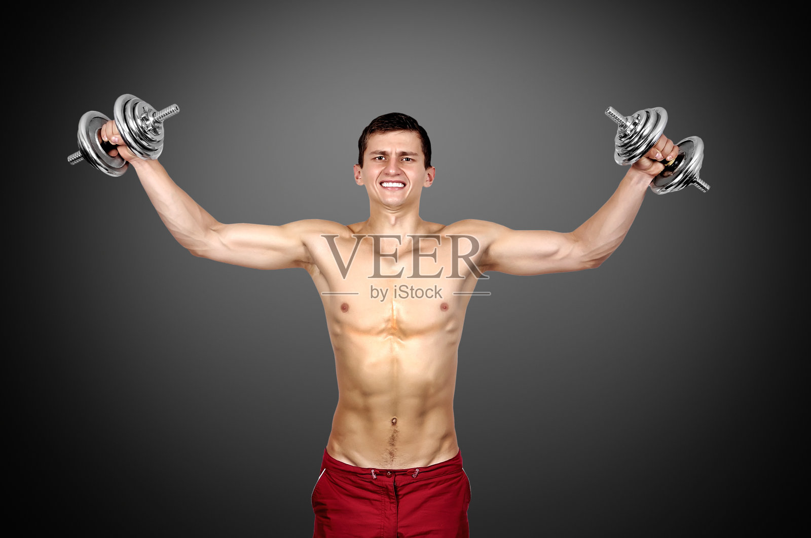 性感肌肉男子举起哑铃照片摄影图片