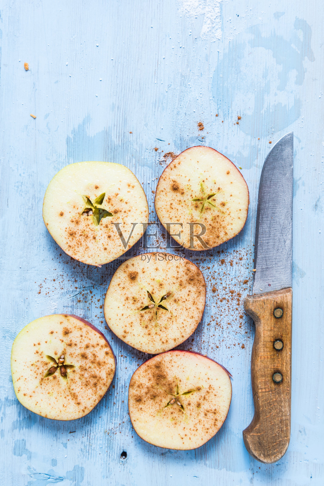 切片的新鲜有机苹果和肉桂在桌子上照片摄影图片