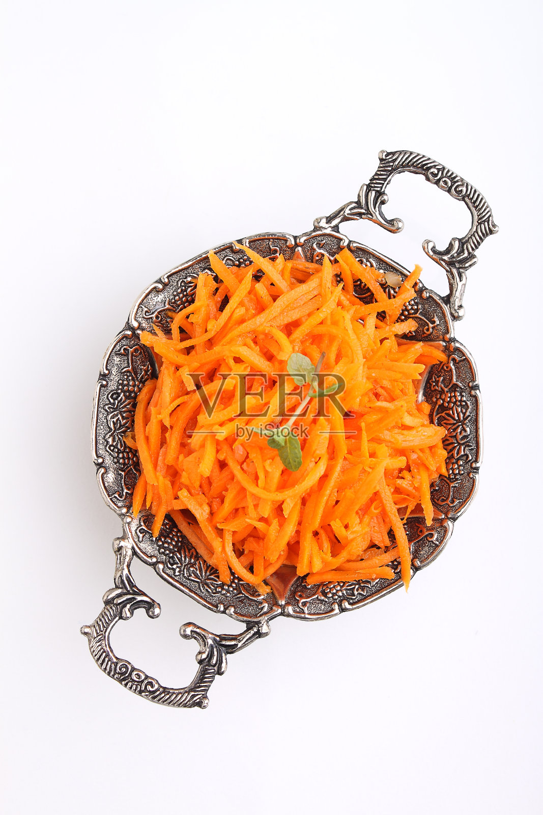 用香料切碎的胡萝卜放在老式金属盘子里照片摄影图片