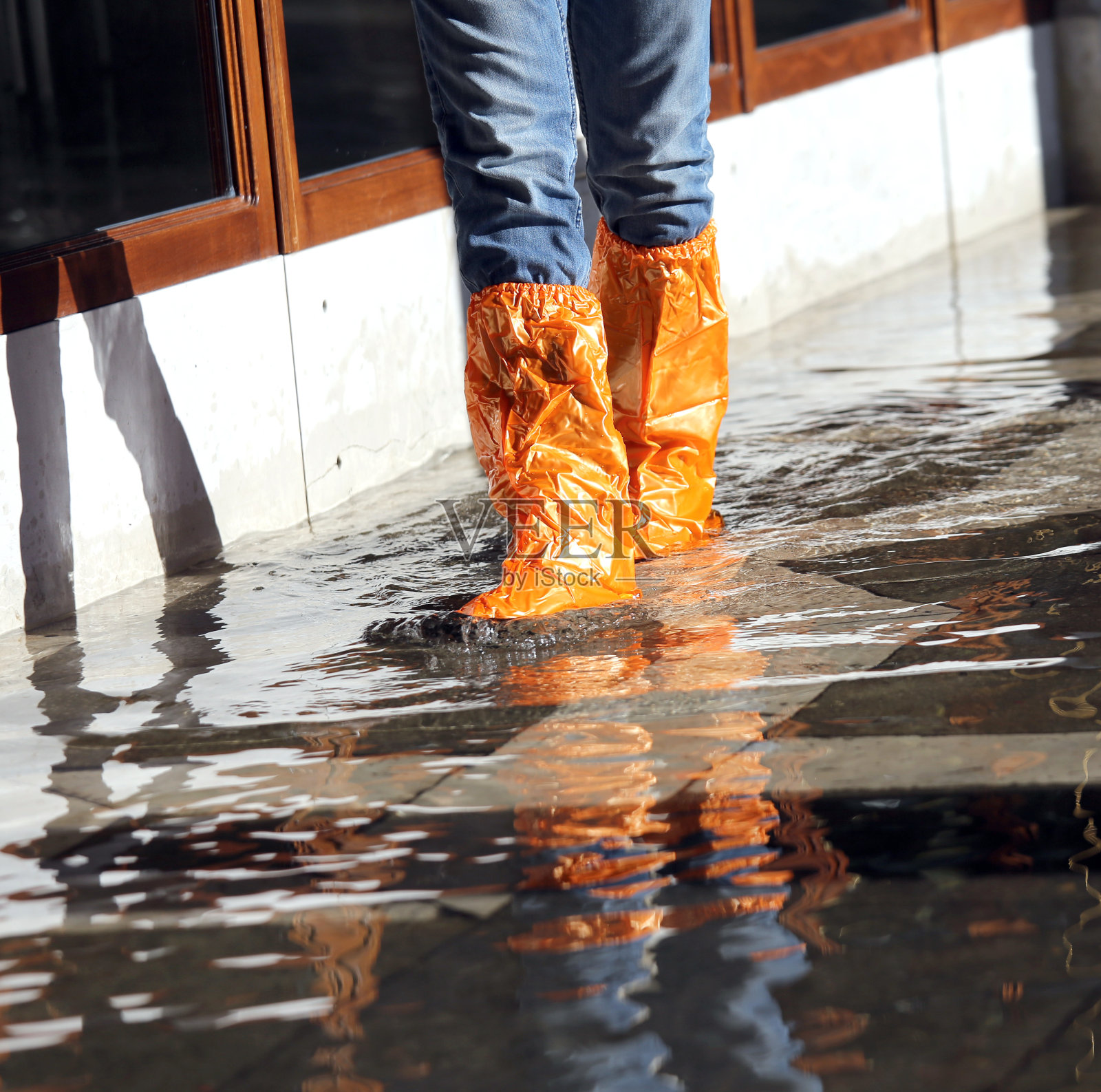 威尼斯涨潮时穿着绑腿的年轻女子照片摄影图片