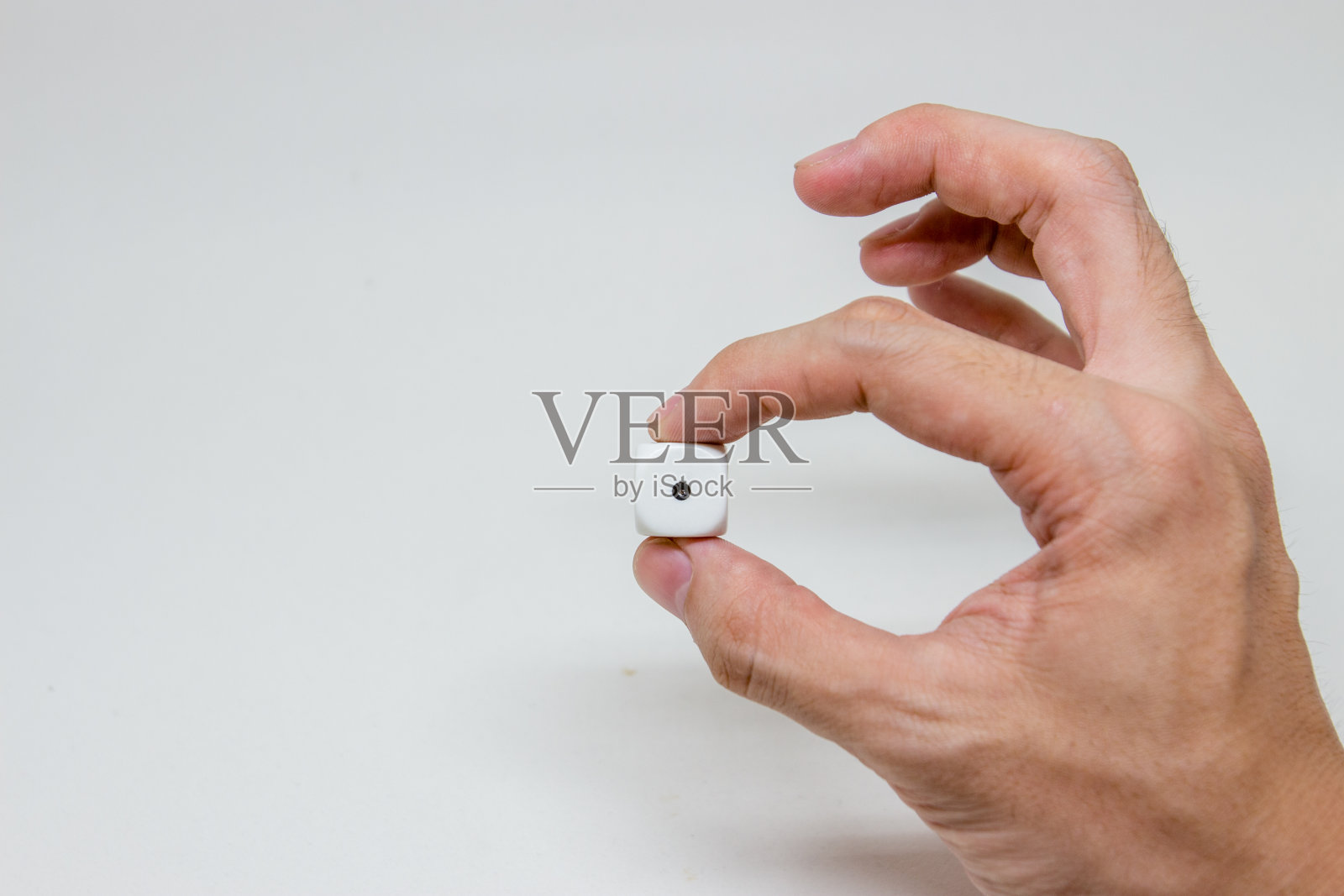 手持一个骰子在白色的背景照片摄影图片