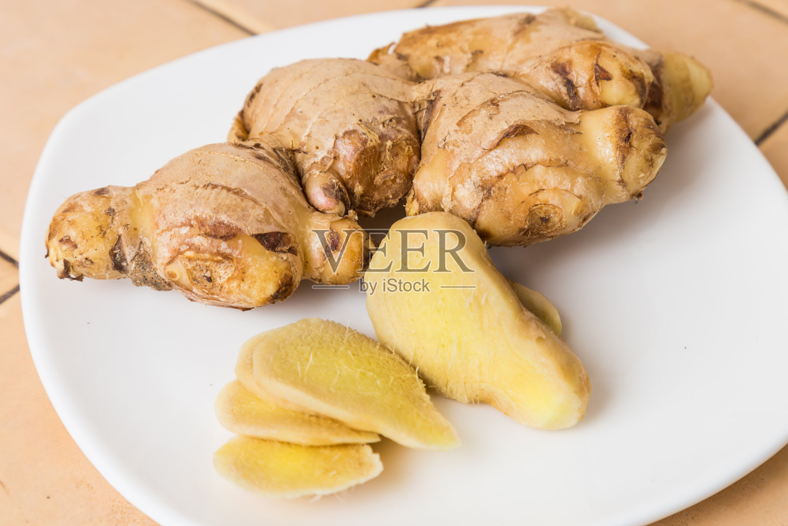 姜根-整根并切成片放在盘中照片摄影图片