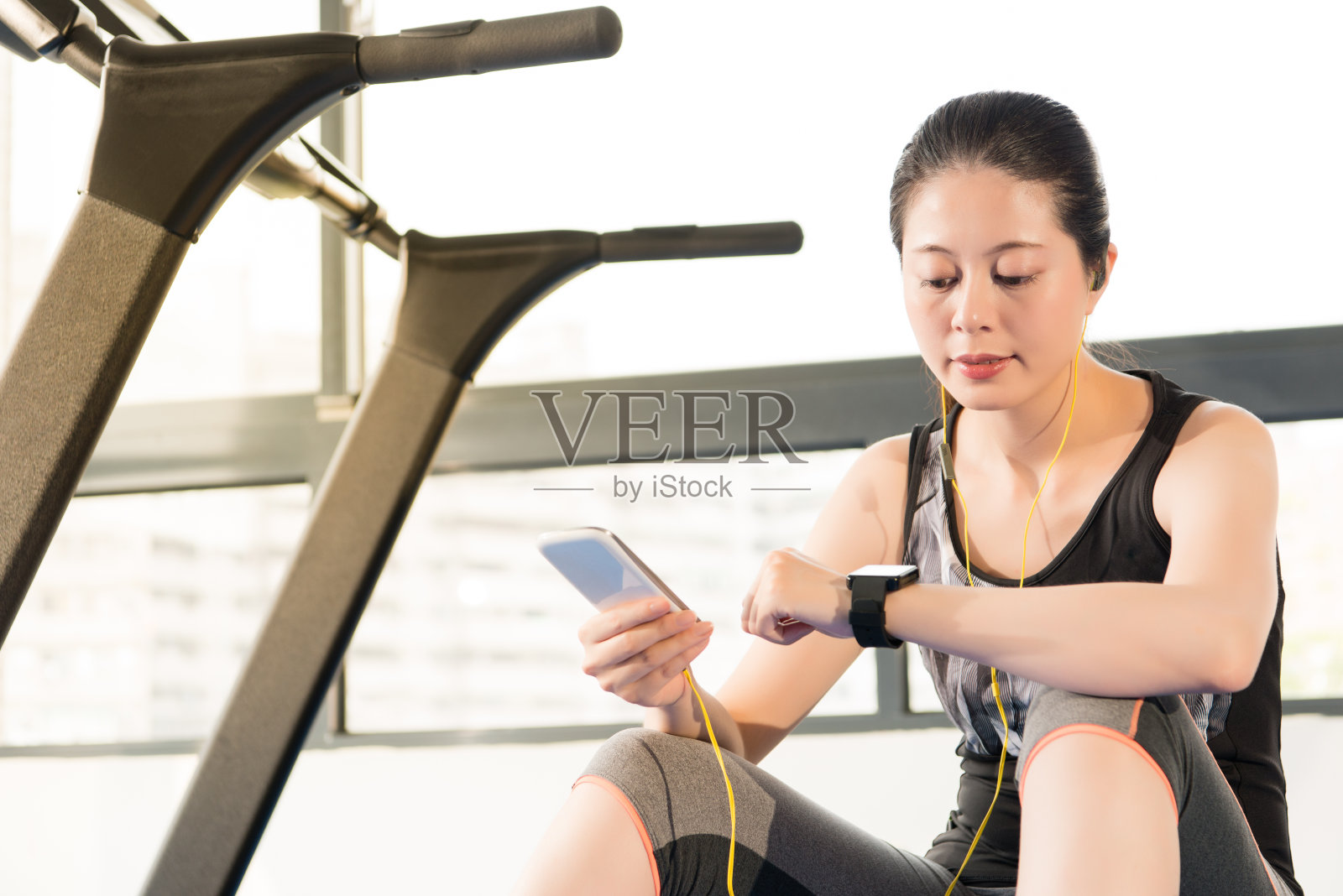 运动亚洲女性用智能手表检查脉搏听照片摄影图片