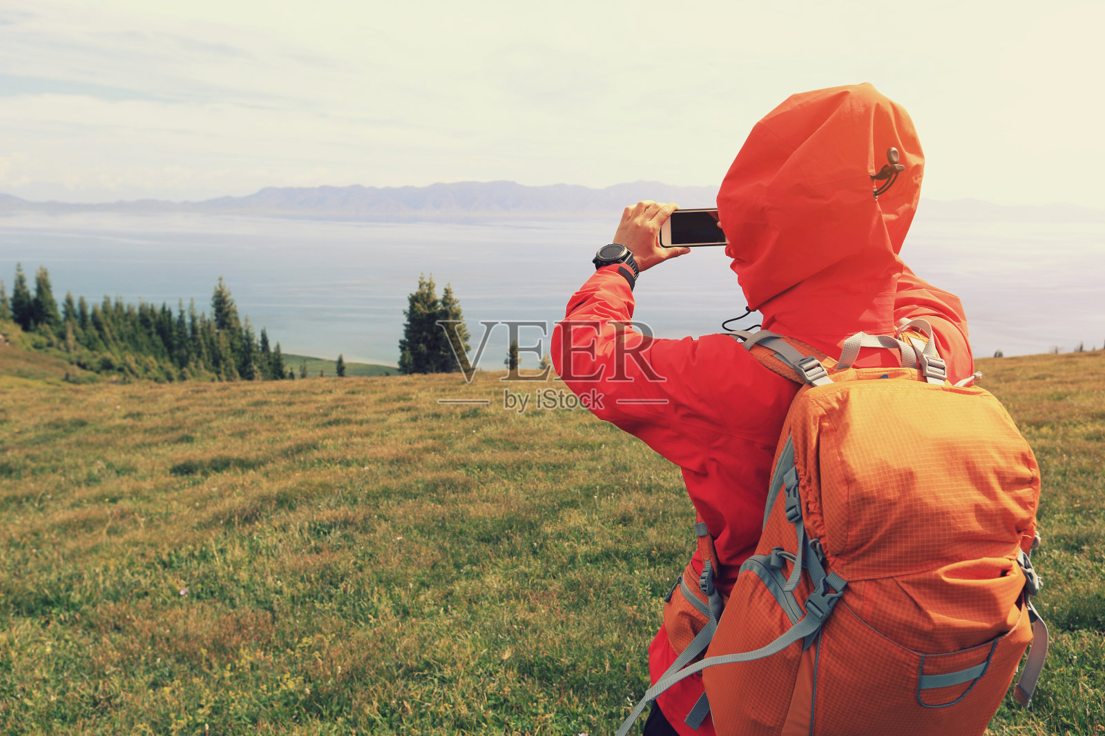 女徒步旅行者在山顶用智能手机拍照照片摄影图片