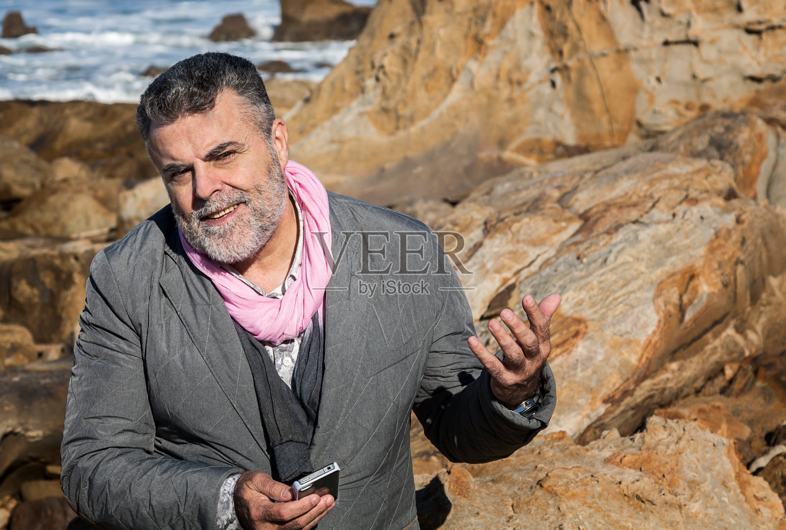 英俊的大胡子男人在海边打电话照片摄影图片