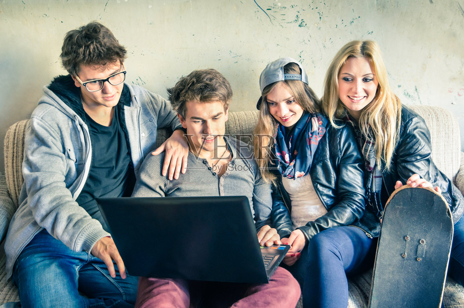 一群时髦的年轻朋友在城市工作室里使用电脑照片摄影图片