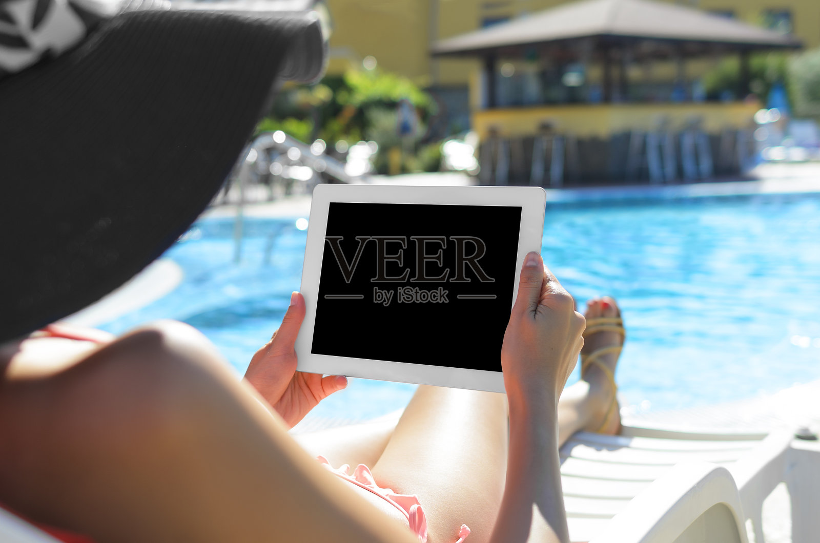 在游泳池里拿着平板电脑的女人照片摄影图片