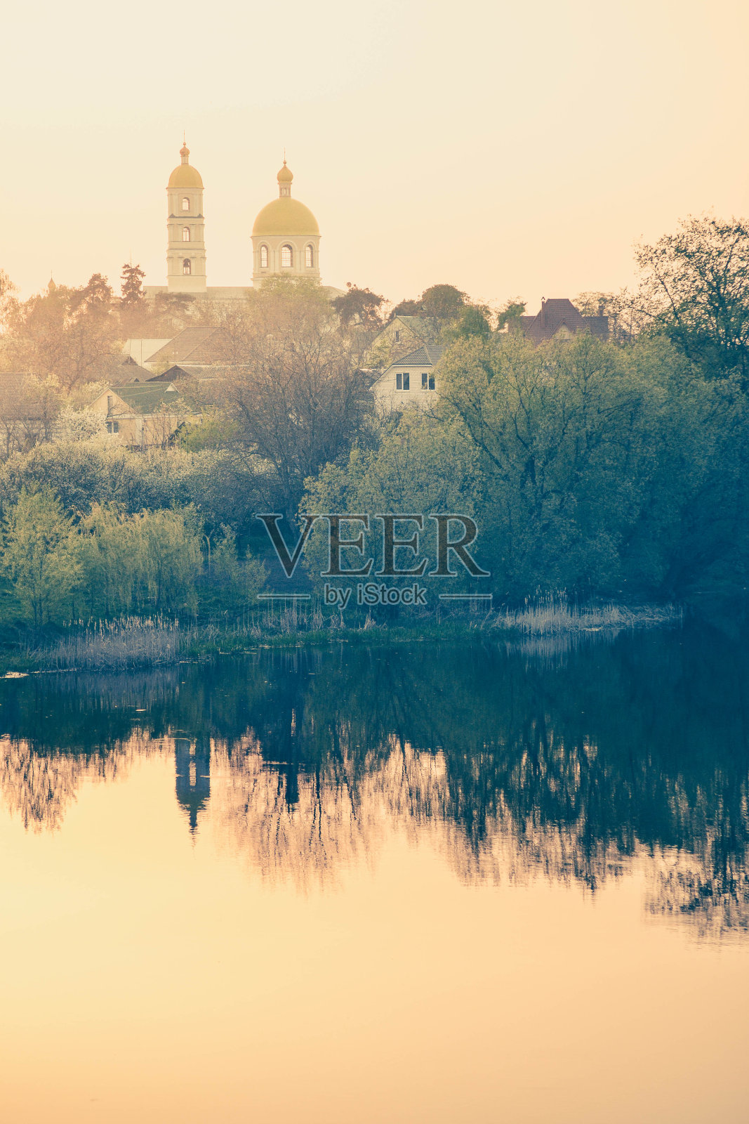 日落时分，黎明时分的教堂和房屋照片摄影图片