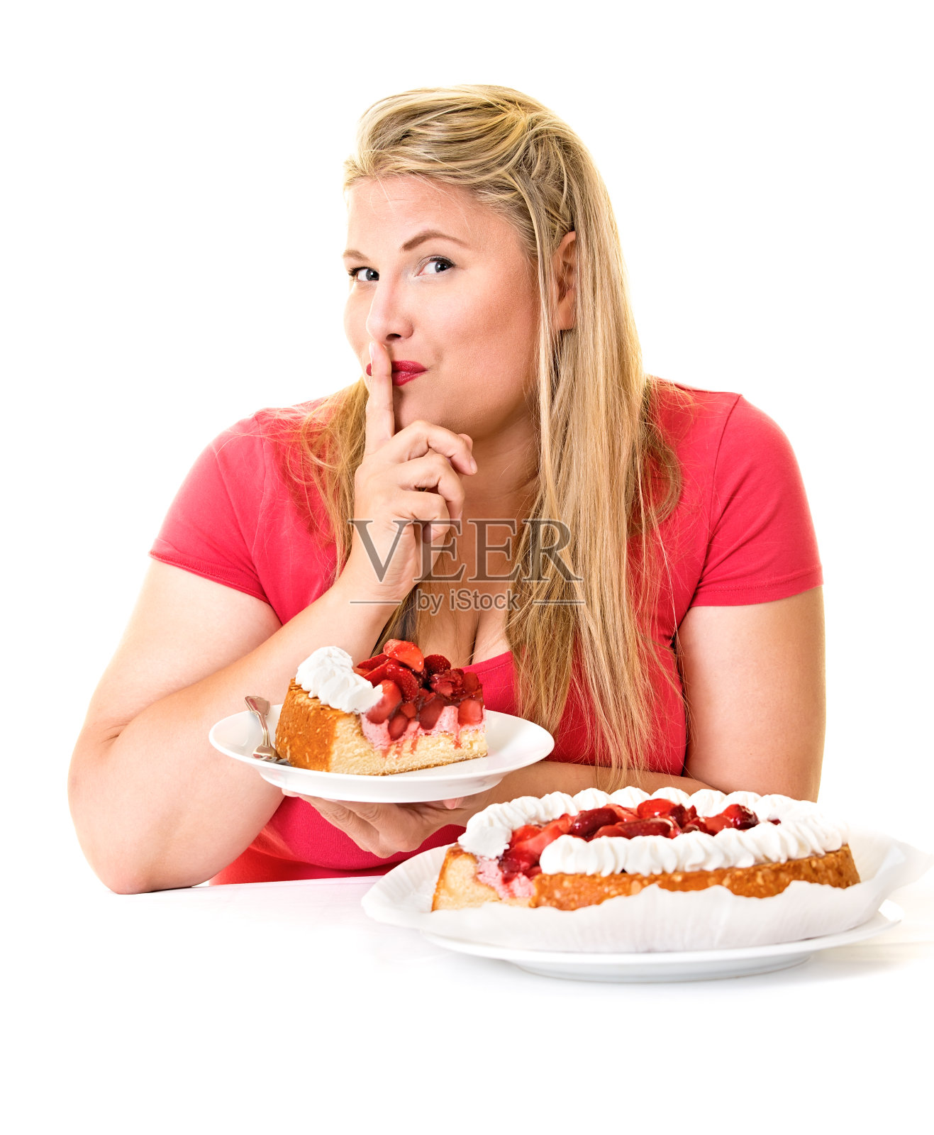 用手指贴着嘴唇，吃着奶油蛋糕的女人。照片摄影图片