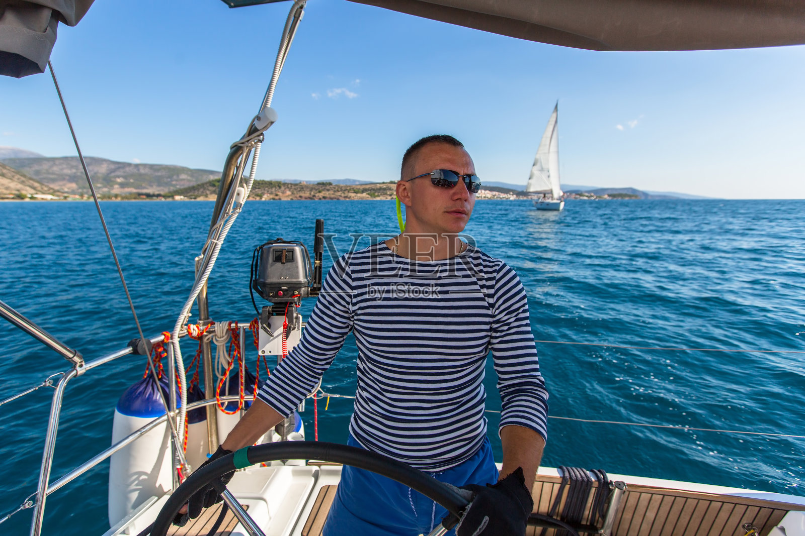 驾驶帆船的船长。照片摄影图片