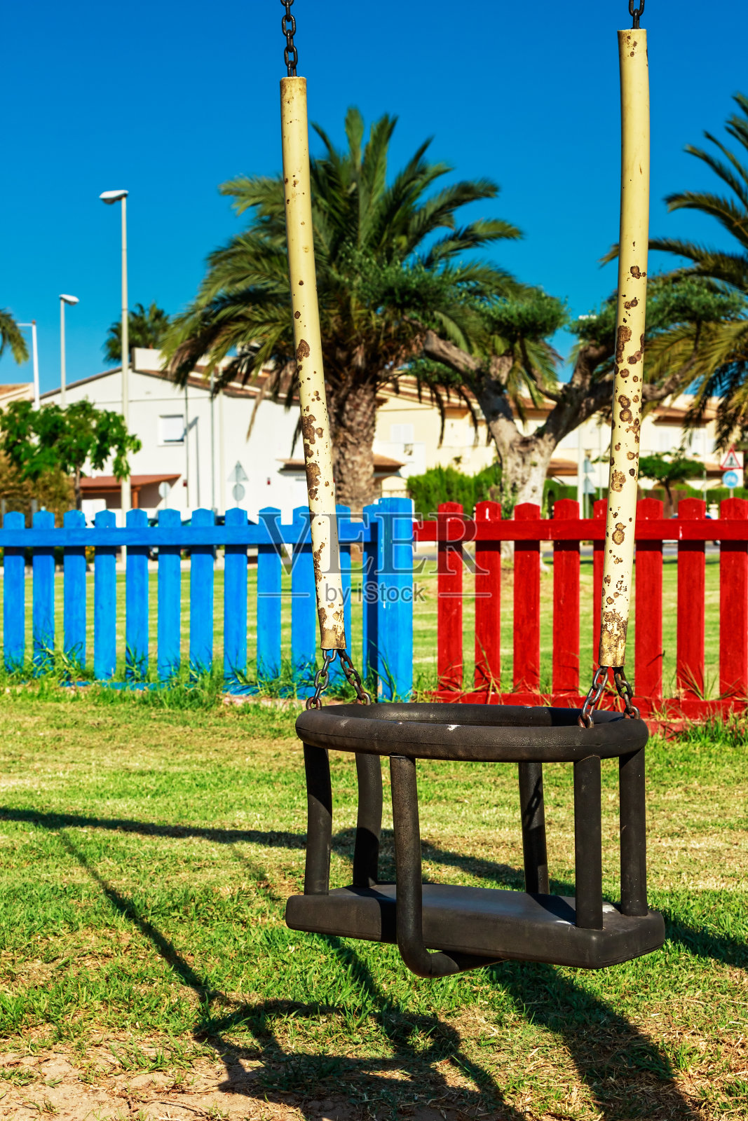 在操场上荡秋千。照片摄影图片