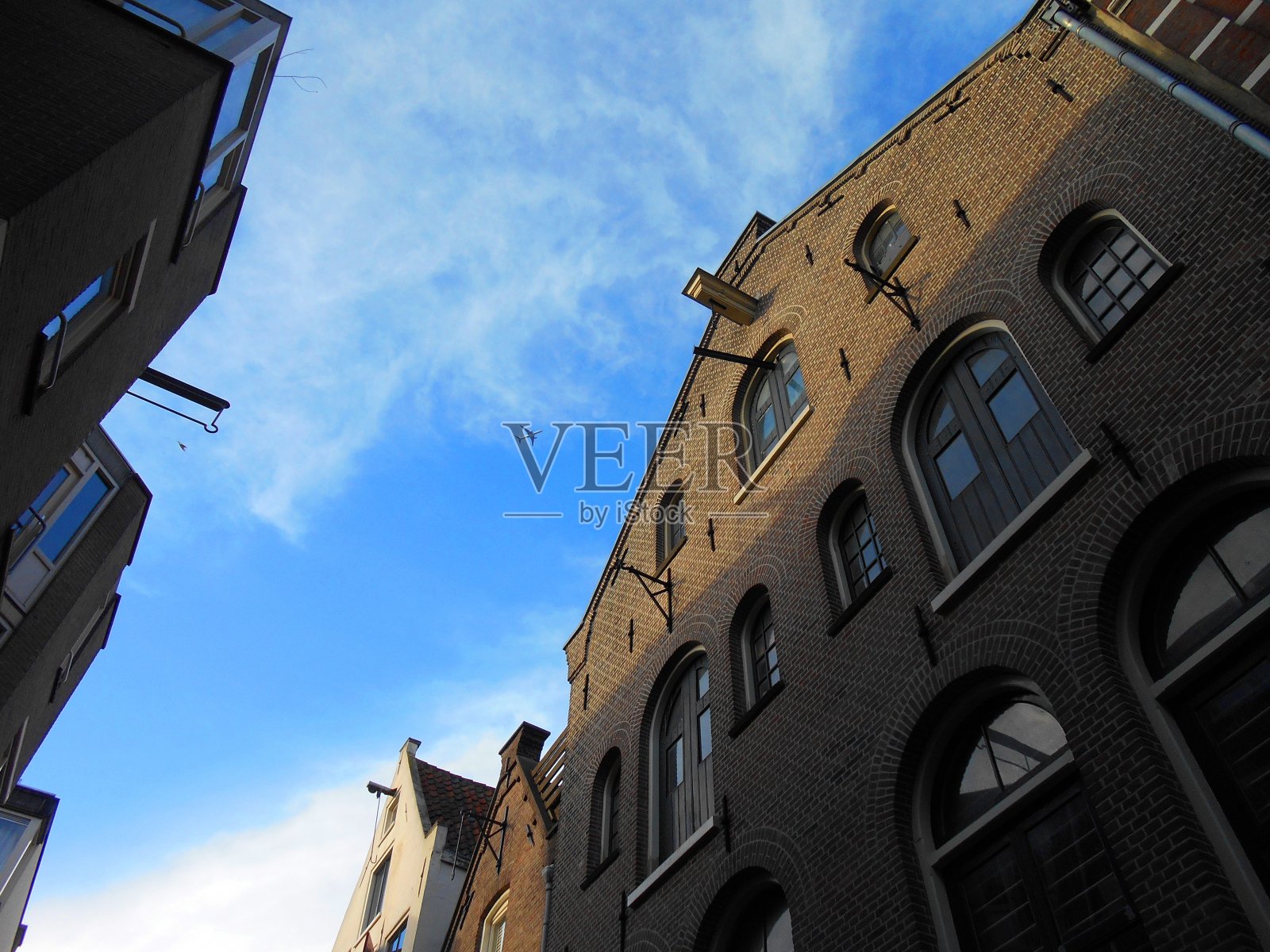 飞机在多云的阿姆斯特丹上空照片摄影图片