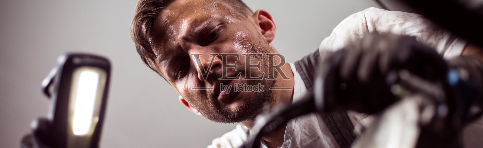 汽车修理工手持手电筒照片摄影图片