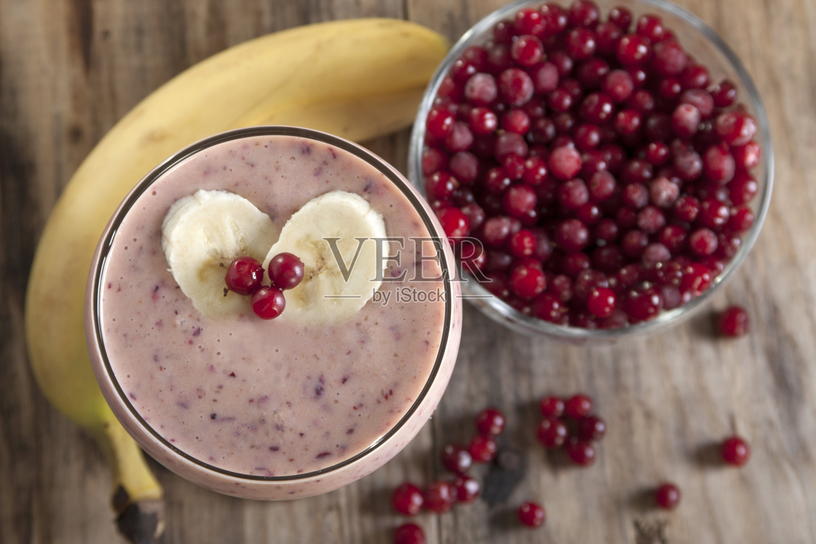 香蕉和冷冻蔓越莓奶昔。照片摄影图片