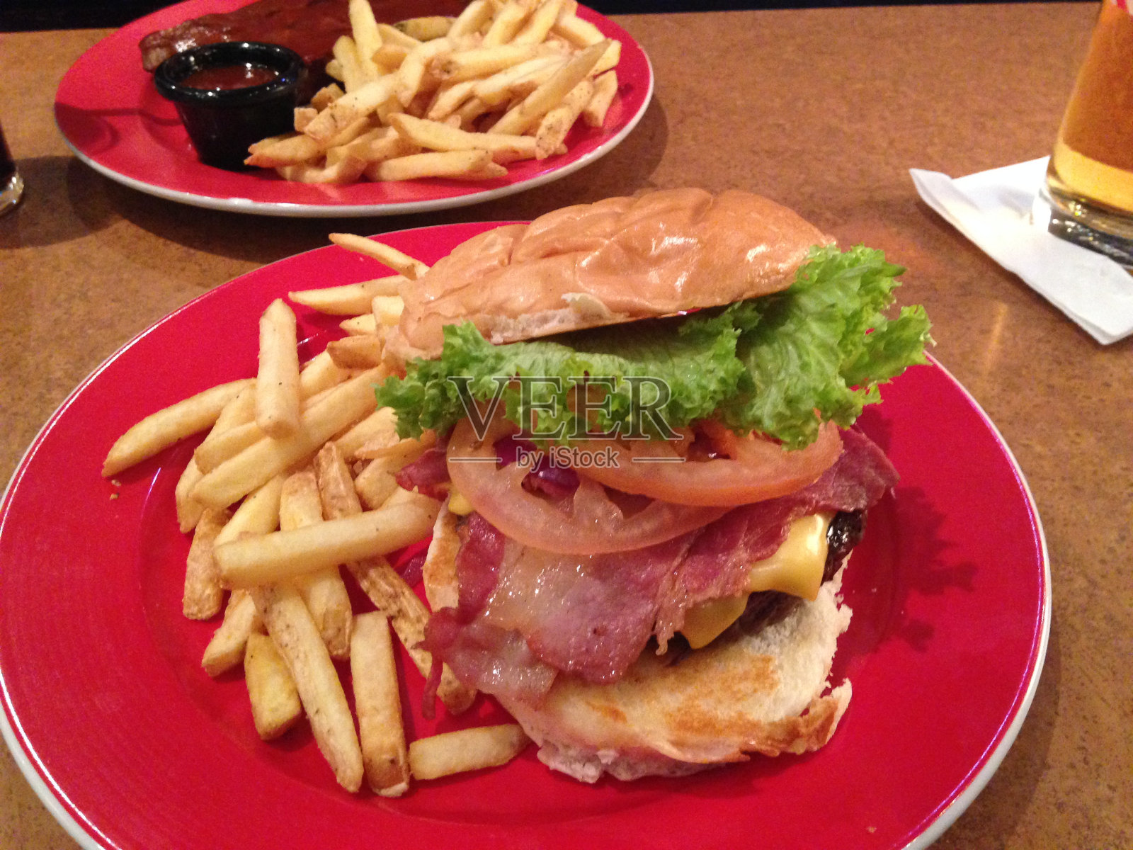 美式汉堡配土豆，西红柿，培根，沙拉和番茄酱照片摄影图片