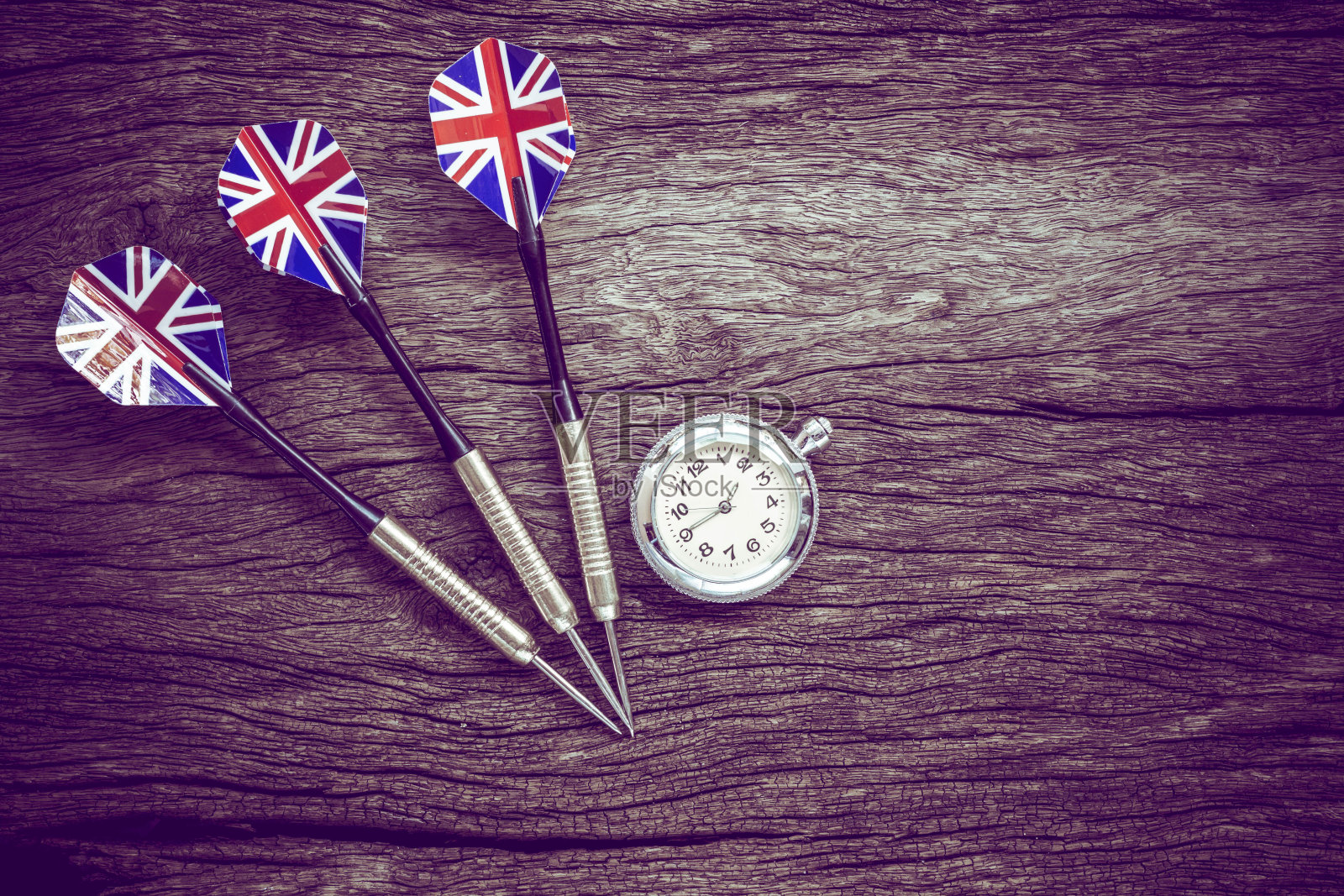 飞镖和观看在旧的木制背景。复古风格。照片摄影图片