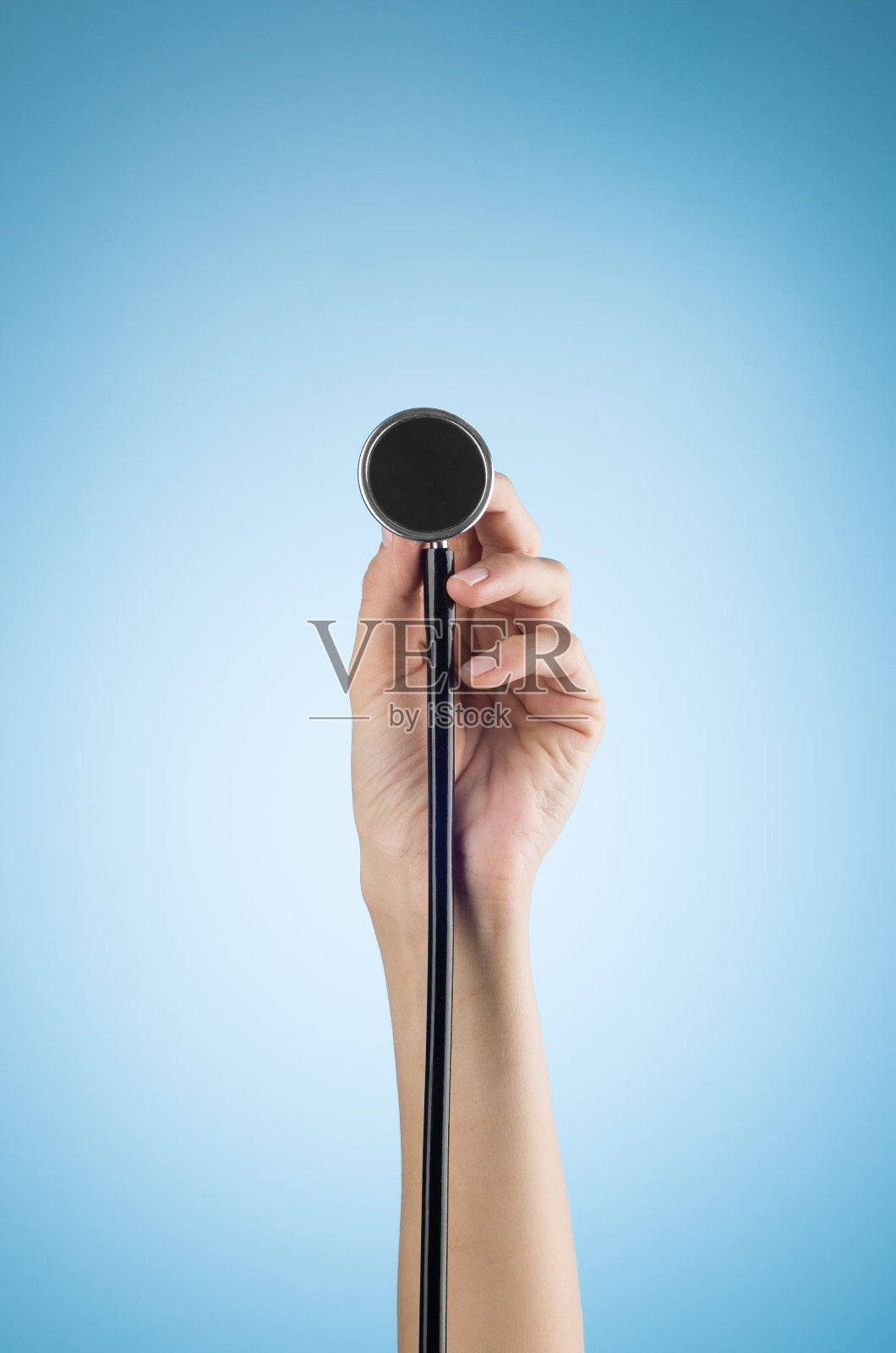 女性手拿听诊器，蓝色背景隔离照片摄影图片