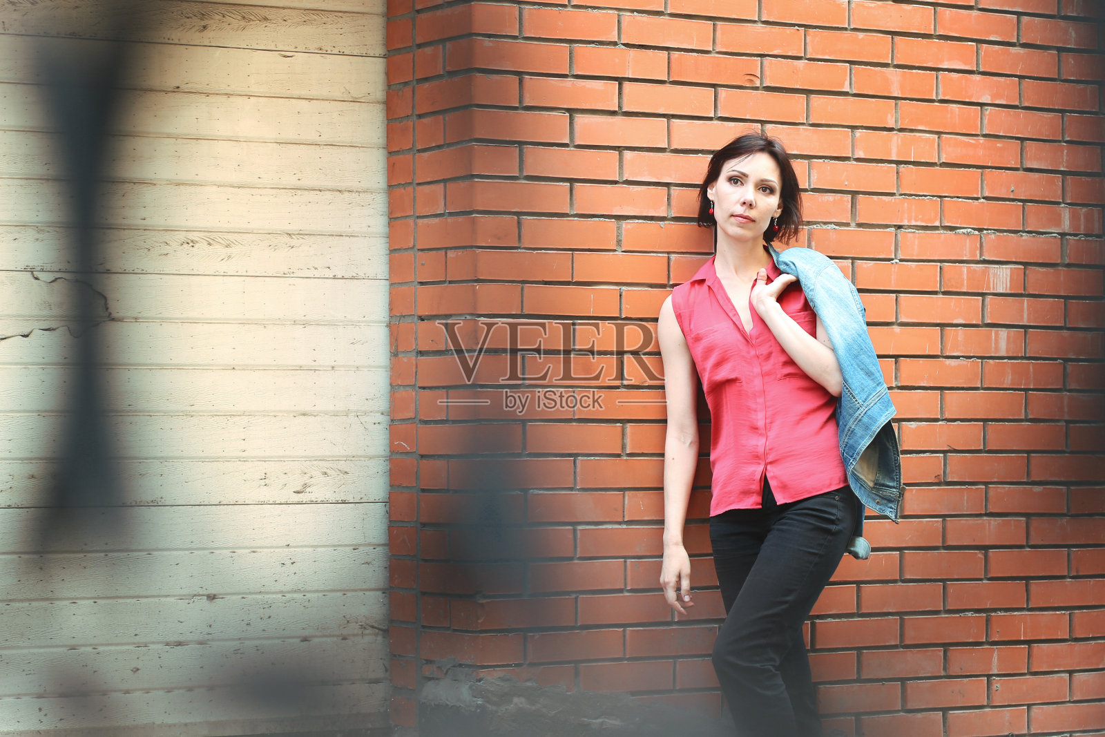 靠近砖墙的女人照片摄影图片