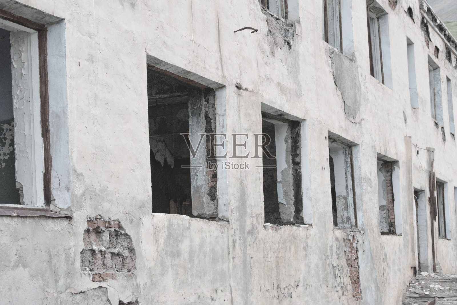 废弃建筑的白墙。破碎的窗户。照片摄影图片