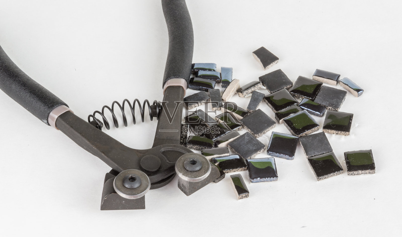 一块块用镊子夹住的马赛克瓷砖照片摄影图片