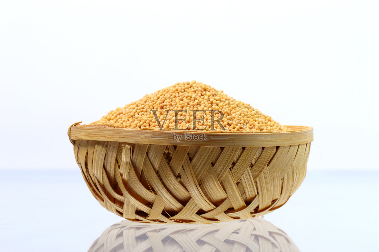 黄芥菜种子在木篮子孤立在白色的背景照片摄影图片