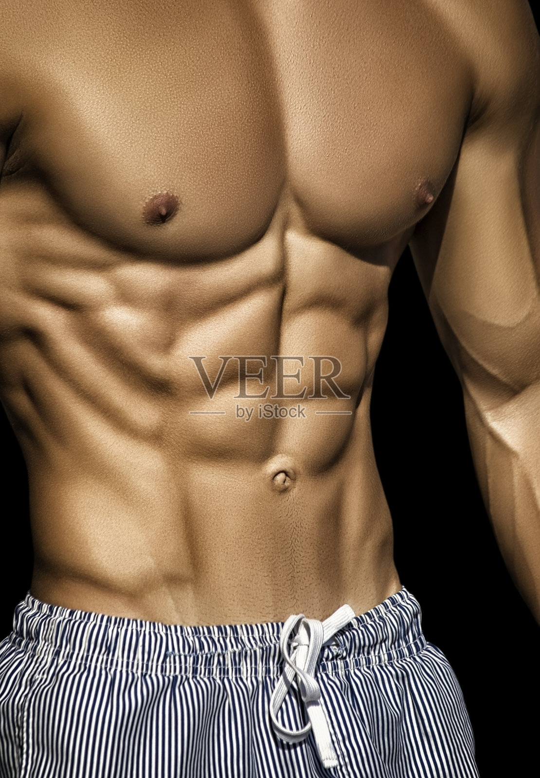 运动。一个面目全非的强壮男人展示着他完美的腹肌照片摄影图片