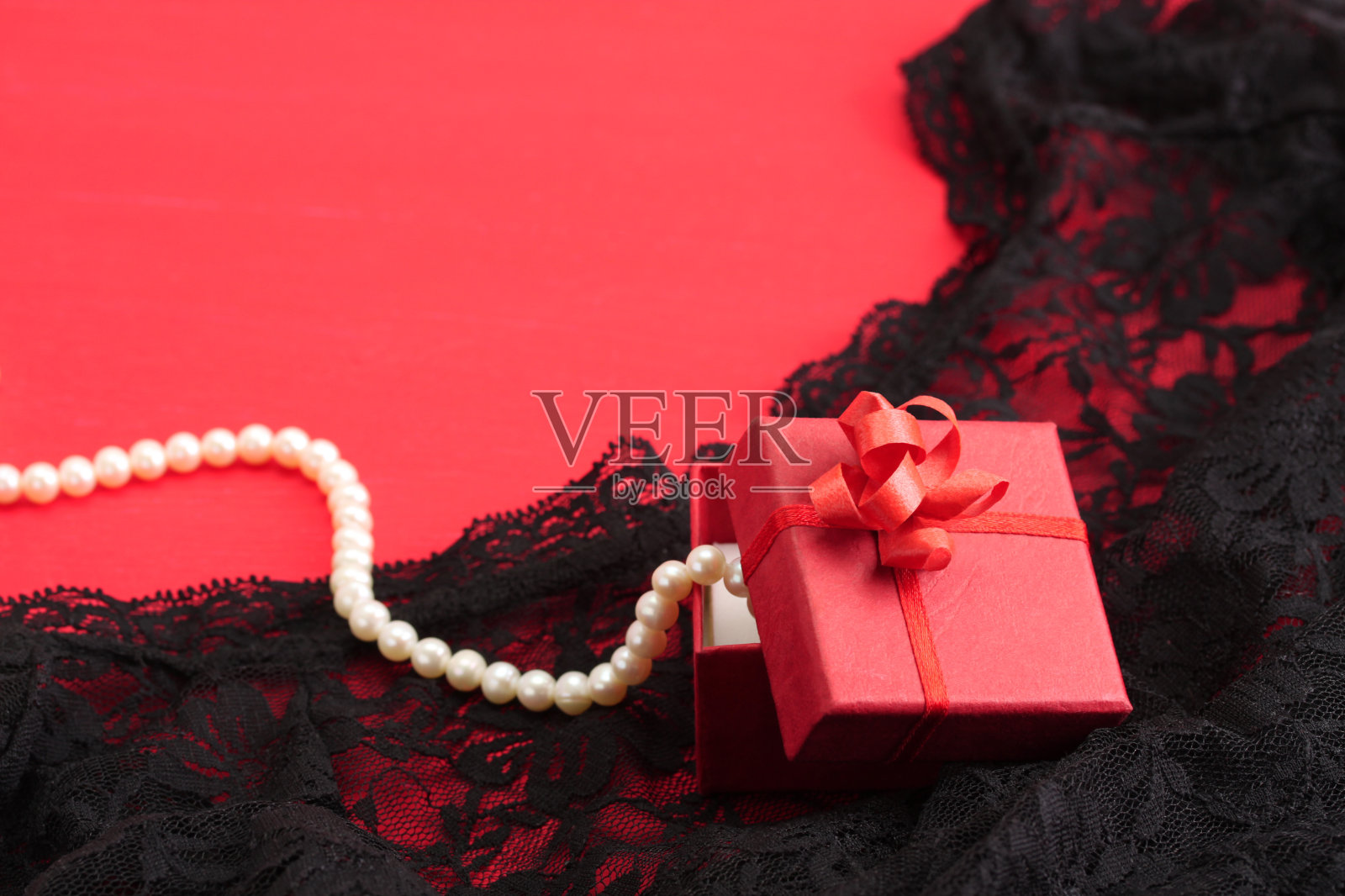 红色礼物和白色珍珠项链上的黑色蕾丝内衣照片摄影图片