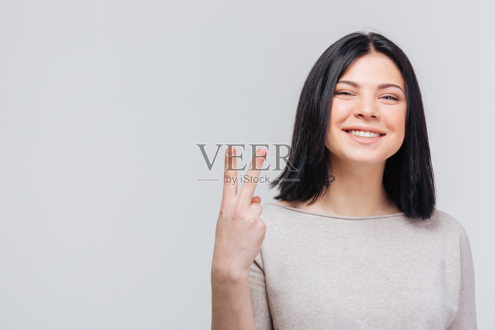 漂亮的女孩在做胜利的手势照片摄影图片