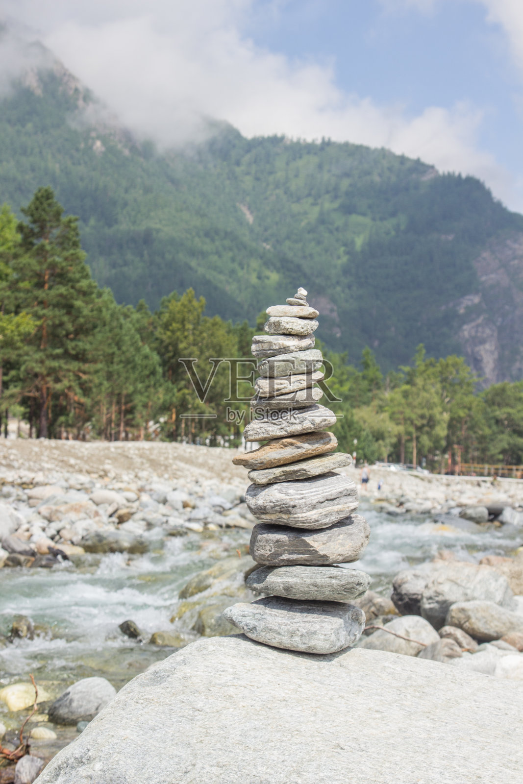 金字塔由石头砌在河堤上，背靠山景。照片摄影图片
