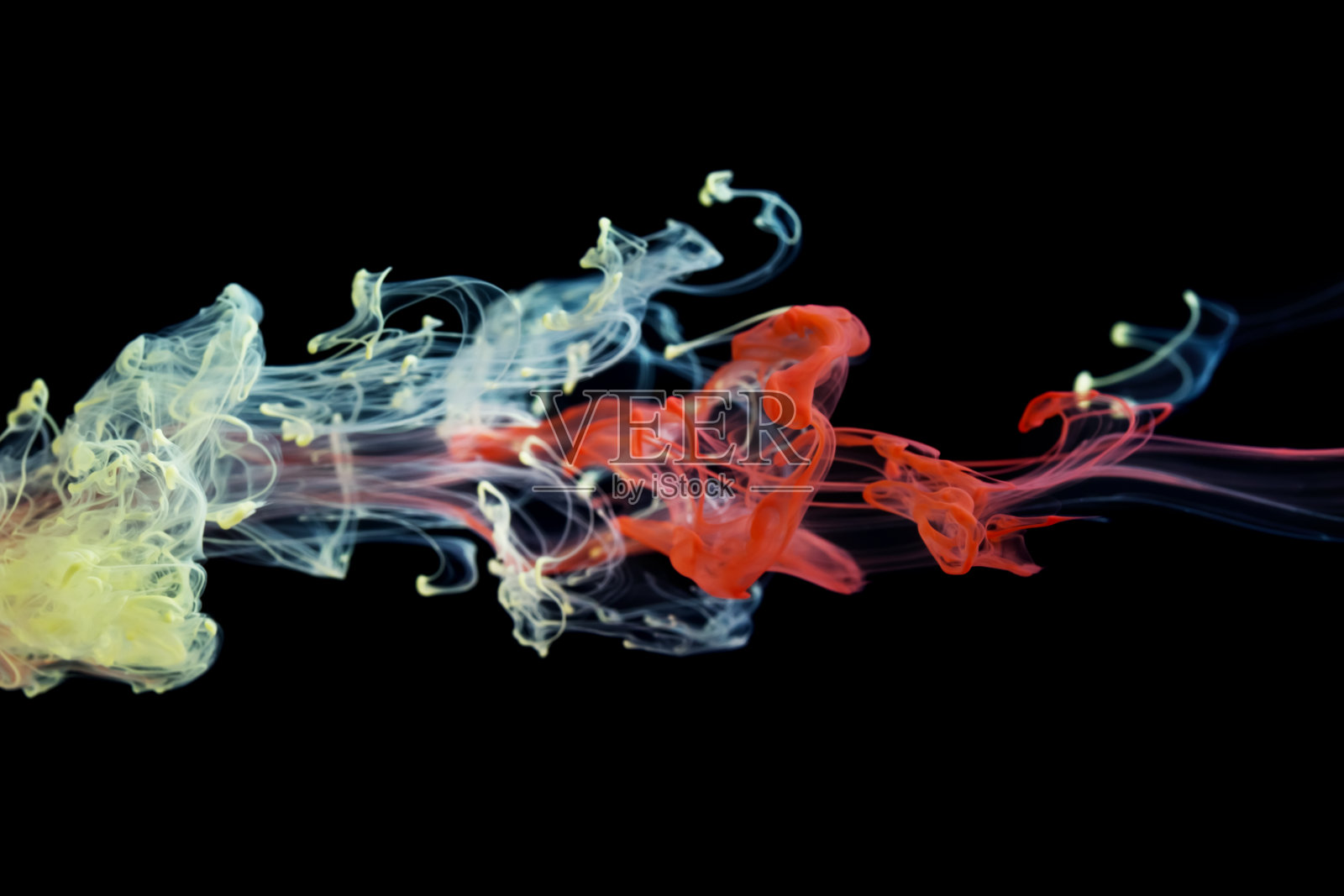 红色和黄色的墨水在水中照片摄影图片