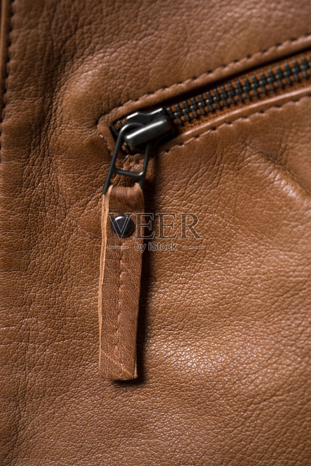 棕色有纹理的皮夹克。皮夹克宏观细节。照片摄影图片