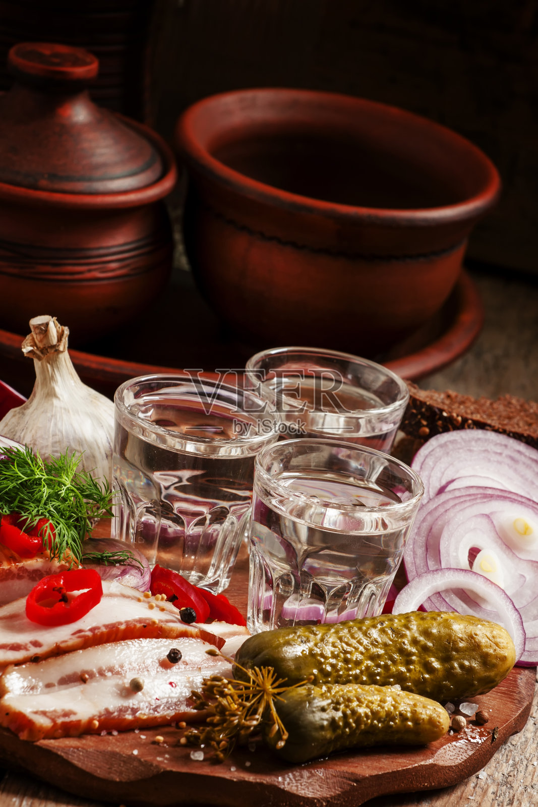 俄罗斯传统:冰镇伏特加和咸肉、腌黄瓜等小吃照片摄影图片