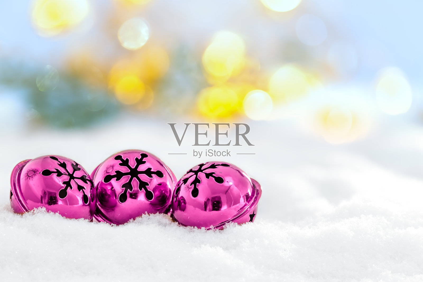 圣诞铃儿在雪的背景和散焦灯照片摄影图片