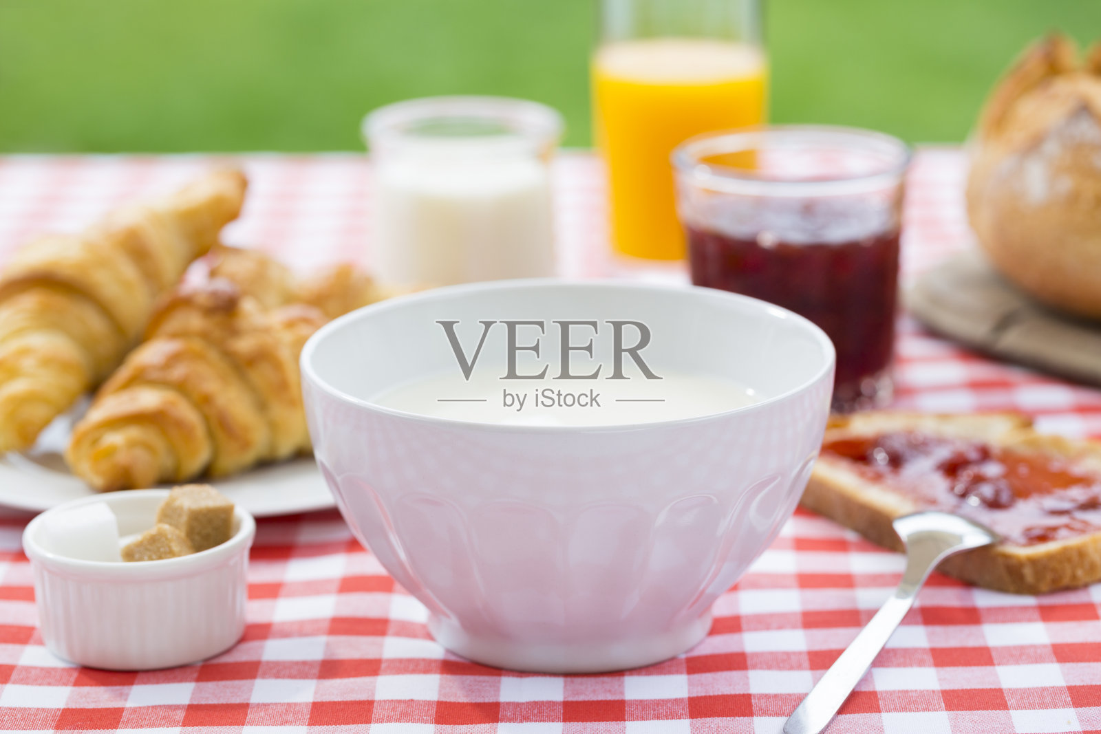 早餐有牛奶，橙汁，羊角面包，果酱和面包花园照片摄影图片