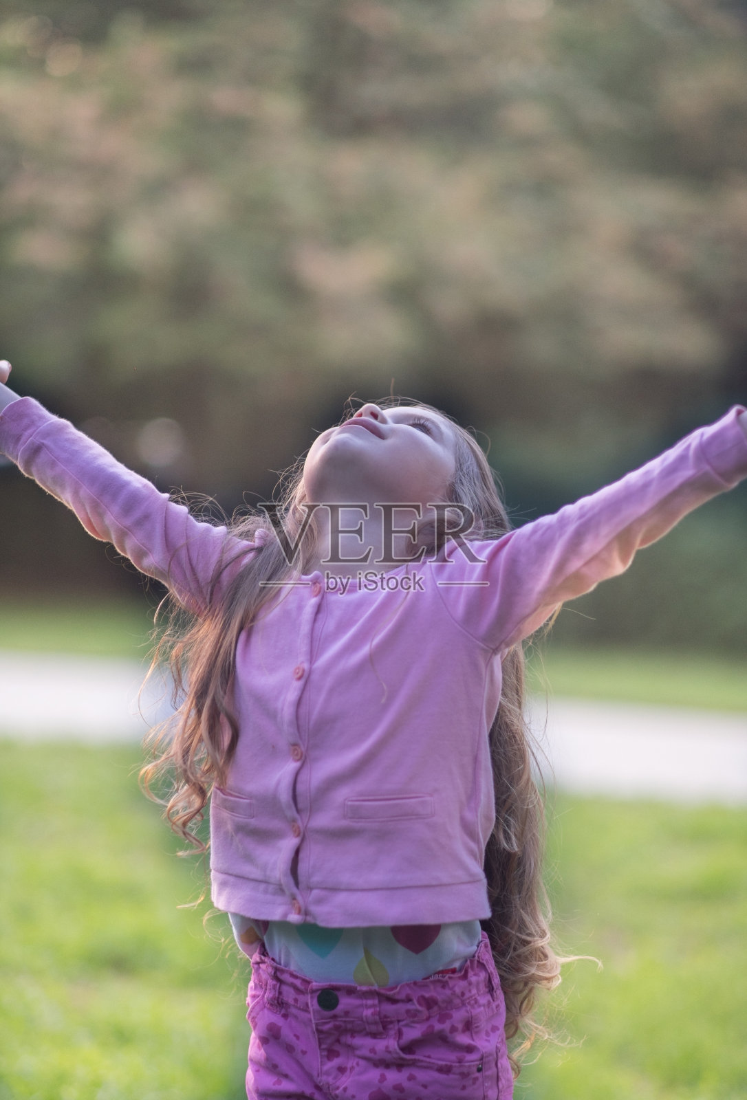 小女孩伸出双臂站着照片摄影图片