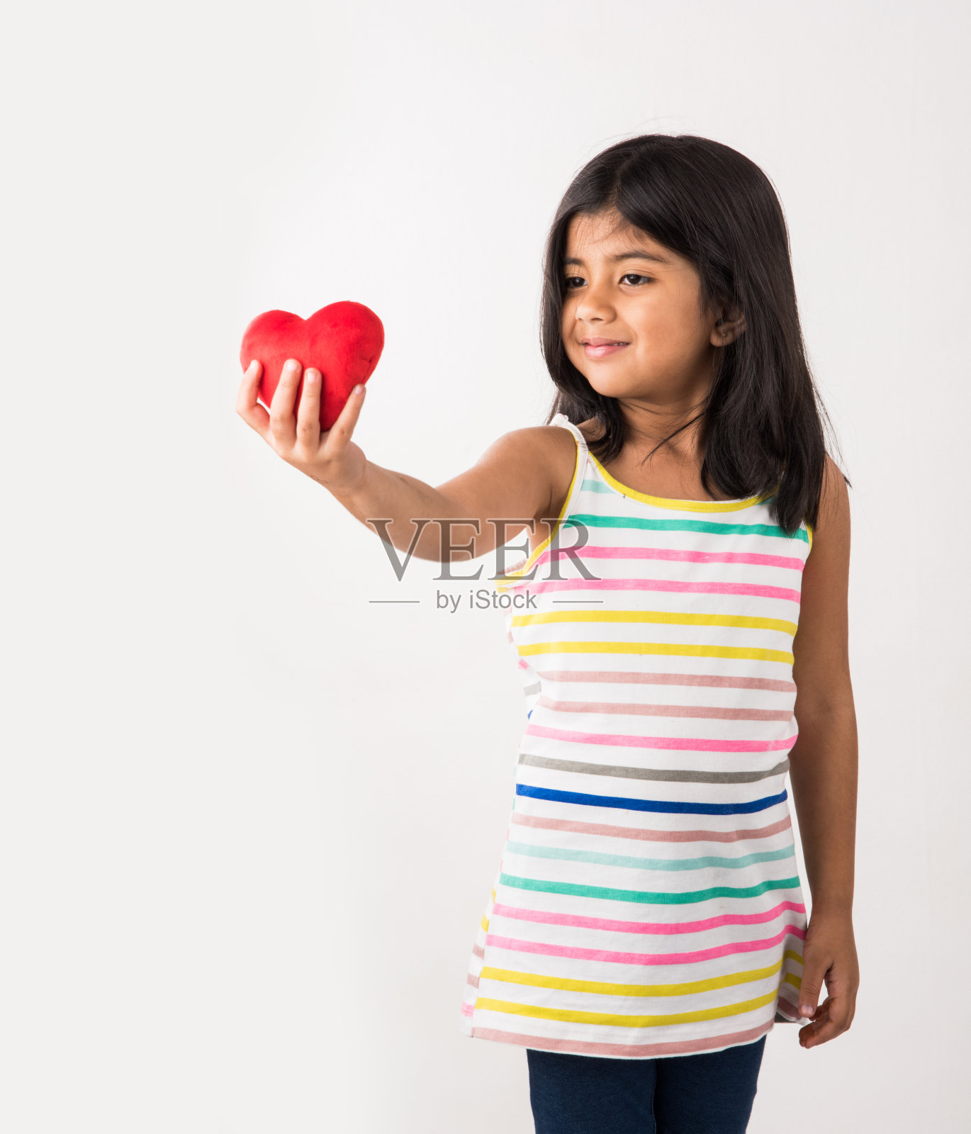 小印度女孩拿着红色填充心玩具照片摄影图片