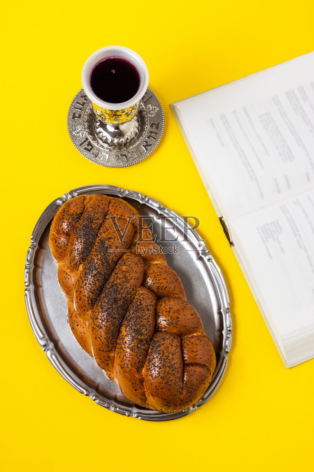安息日，托盘上的面包，基德什，黄色背景上的书。照片摄影图片