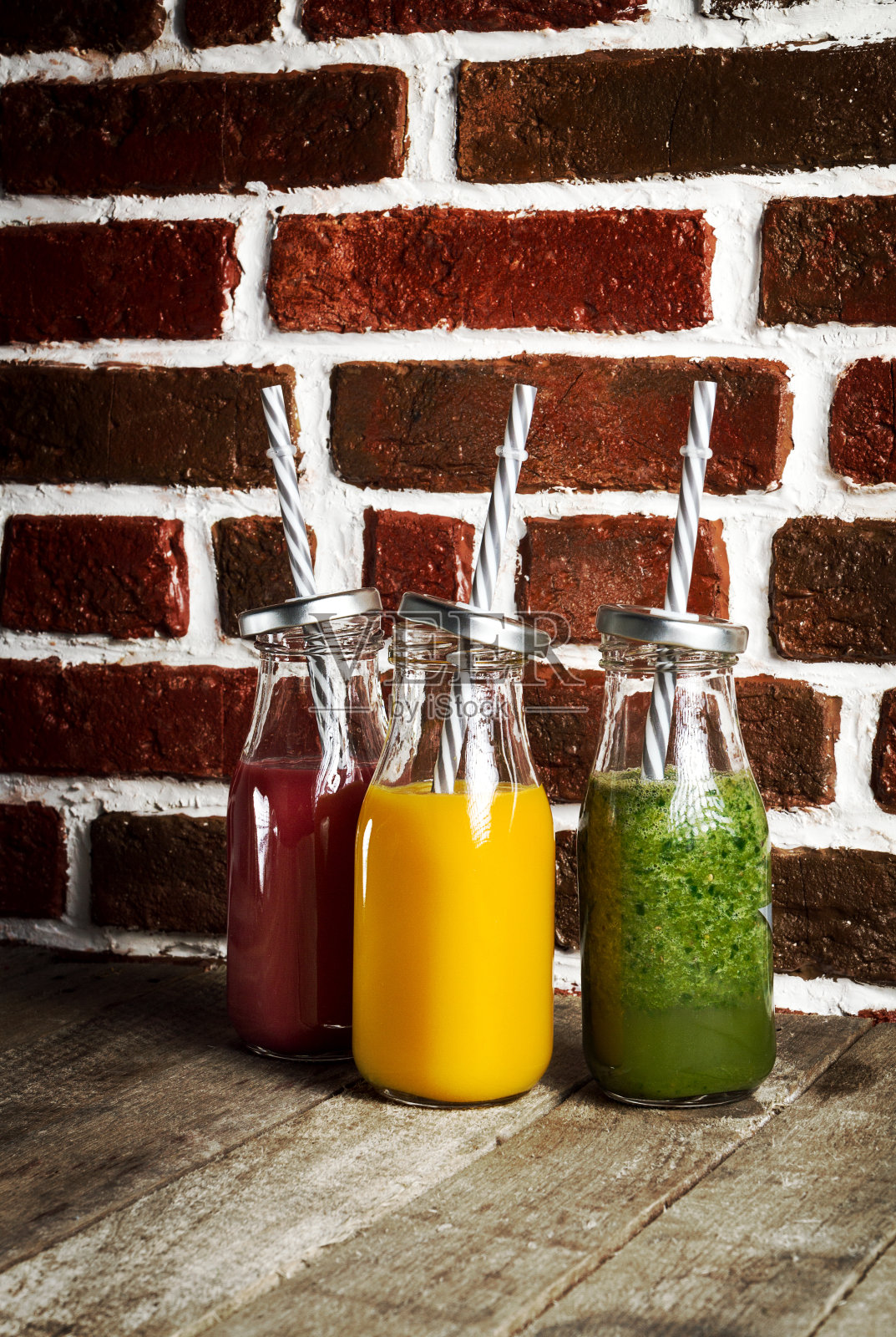 美味的彩色新鲜的自制冰沙在玻璃罐在木桌上。照片摄影图片