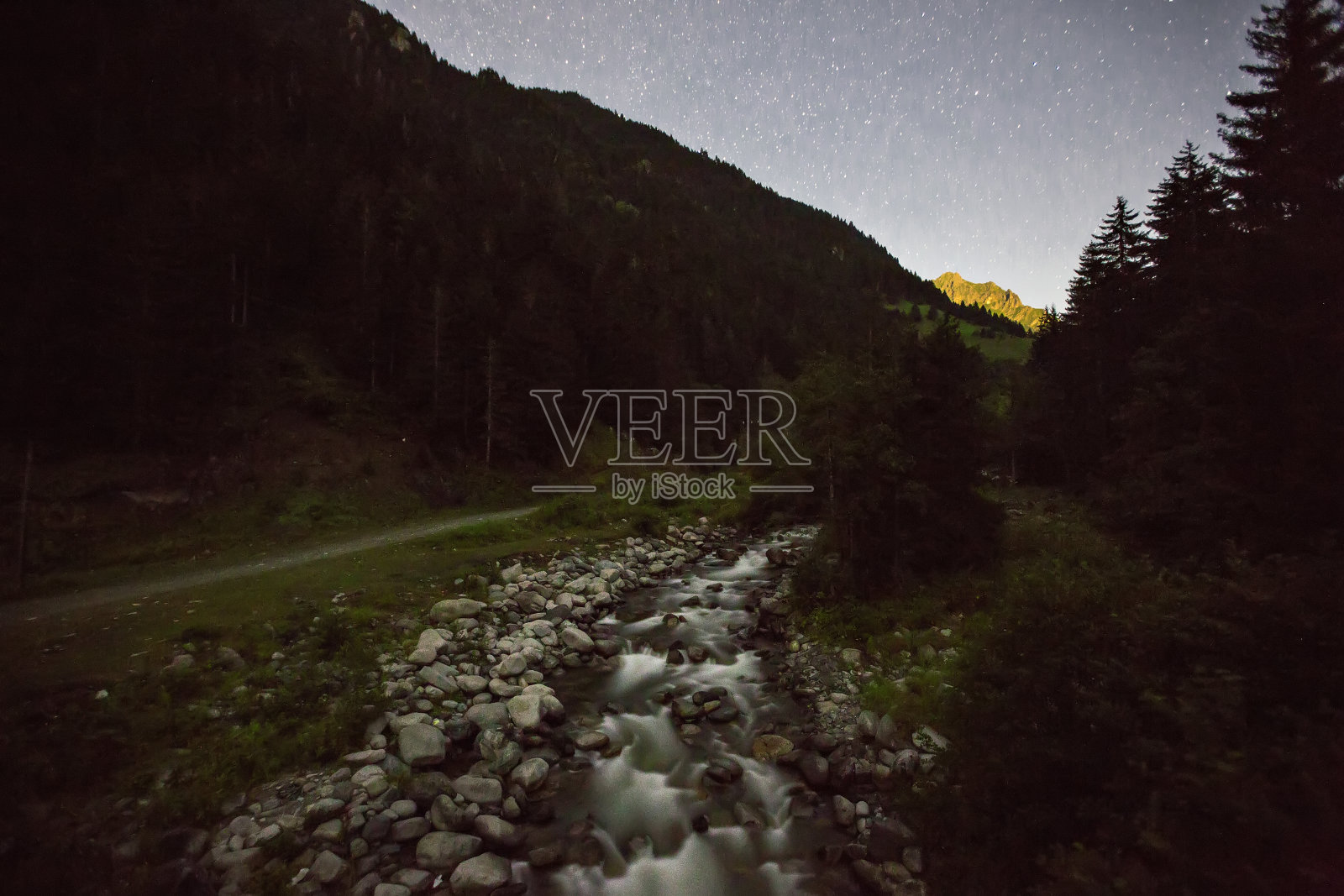 日落时山间森林中的小溪照片摄影图片