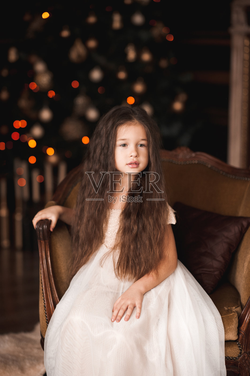 可爱的小女孩在圣诞树上照片摄影图片