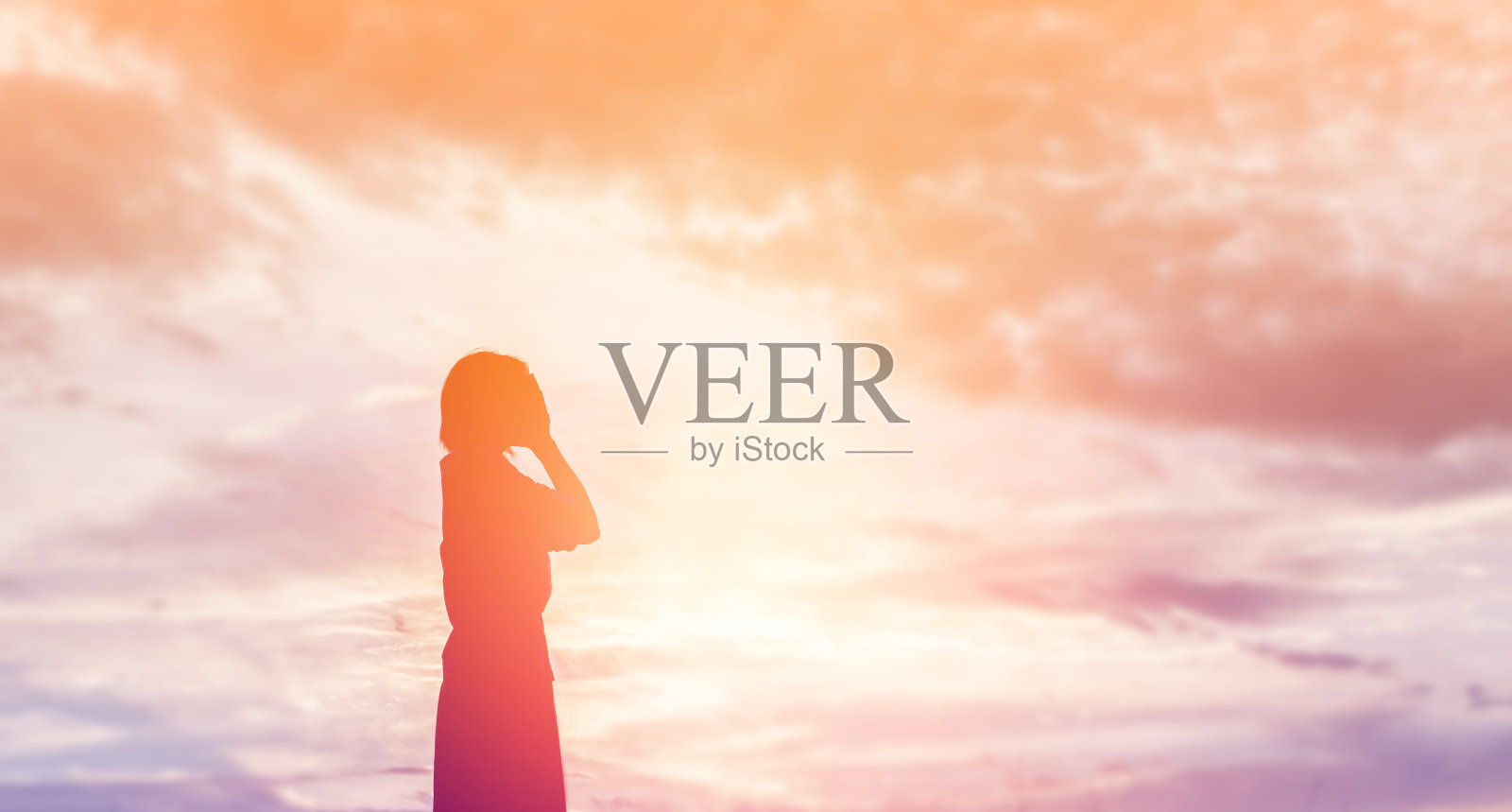 女人的剪影祈祷在美丽的天空背景照片摄影图片