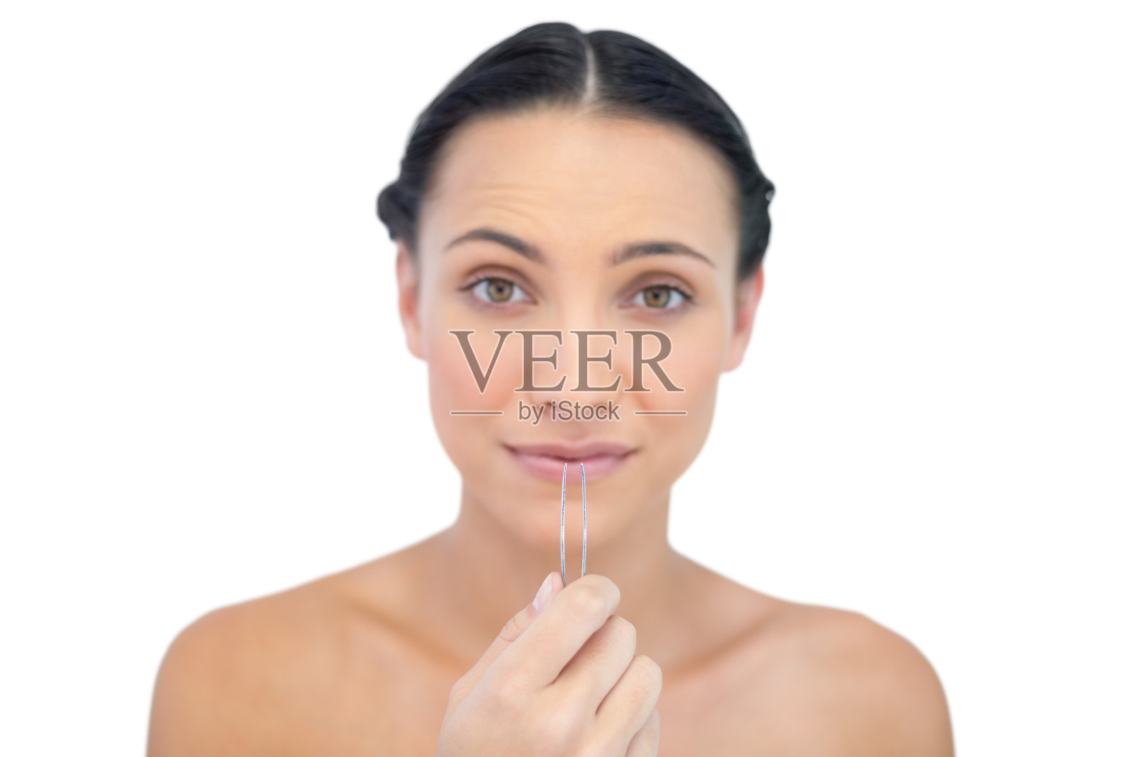 焦虑的年轻褐发女人拿着镊子照片摄影图片