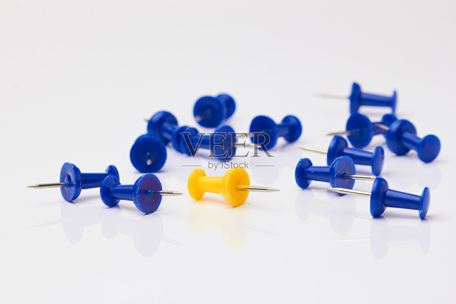 白色背景上的蓝色和黄色图钉。照片摄影图片
