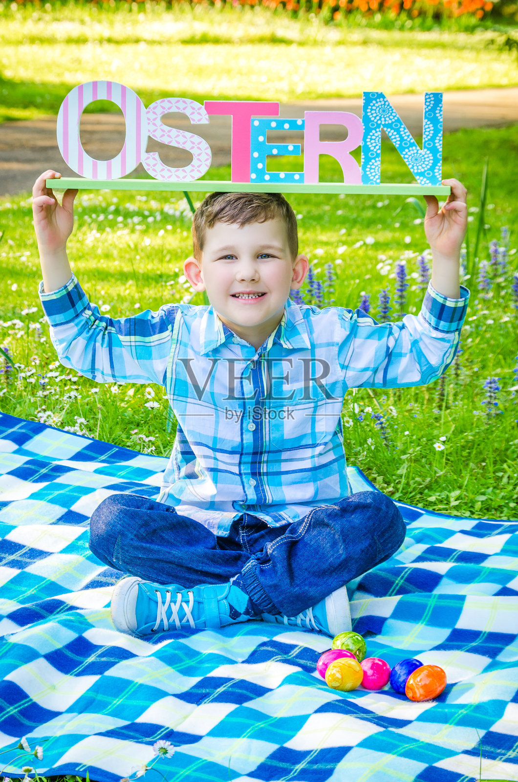 孩子在草地上展示了“复活节”这个词照片摄影图片