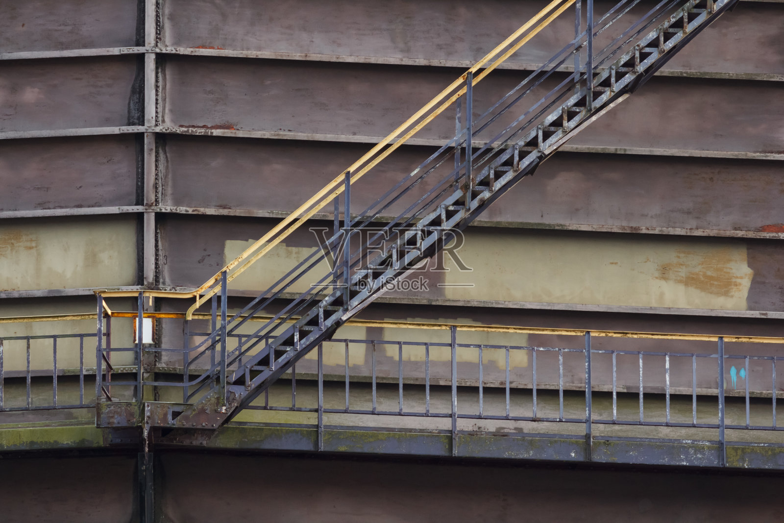 一个巨大的棕色筒仓上的工业梯子照片摄影图片